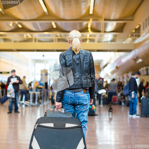 Image of Female traveller walking airport terminal.