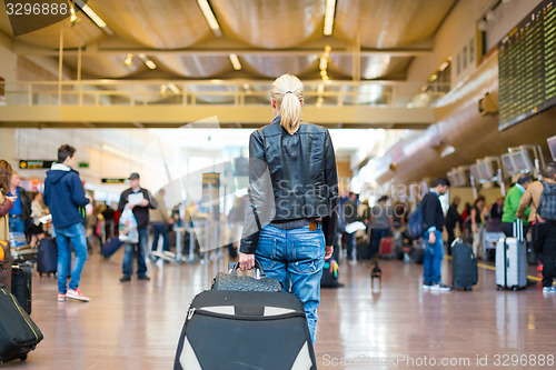 Image of Female traveller walking airport terminal.