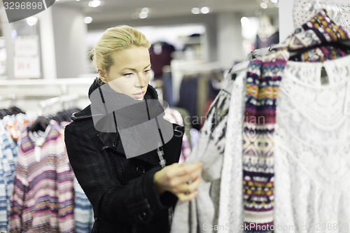 Image of Beautiful woman shopping in clothing store.