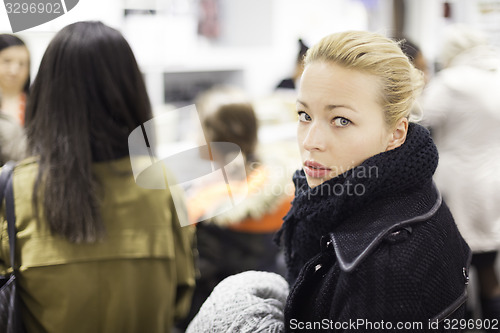 Image of Female shopper queuing in line at cashier.