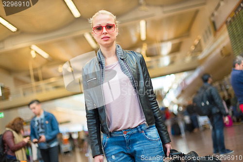 Image of Female traveller walking airport terminal.