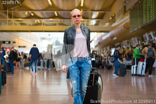 Image of Female traveller walking airport terminal.