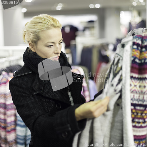 Image of Beautiful woman shopping in clothing store.