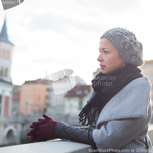 Image of Thoughtful woman outdoors on cold winter day.