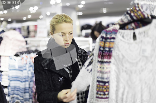 Image of Beautiful woman shopping in clothing store.