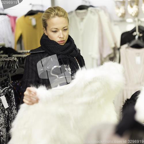 Image of Beautiful woman shopping in clothing store.