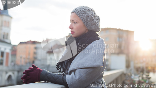 Image of Thoughtful woman outdoors on cold winter day.