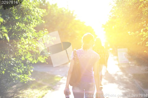 Image of walking woman on sunrise