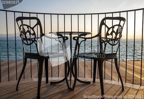 Image of Terrace lake view with iron chairs and table