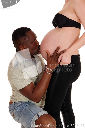 Image of Black man kissing baby belly.