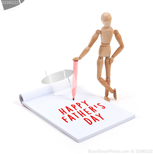 Image of Wooden mannequin writing in scrapbook - Happy fathers day