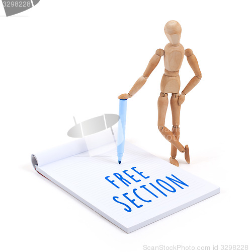 Image of Wooden mannequin writing in scrapbook - Free section