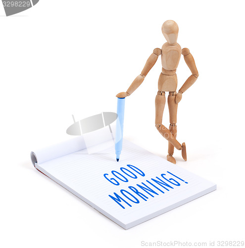 Image of Wooden mannequin writing in scrapbook - Good morning