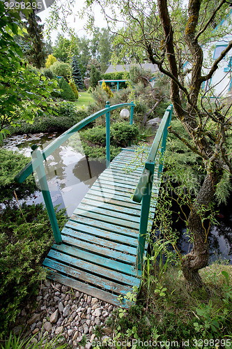 Image of small green footbridge over a pond