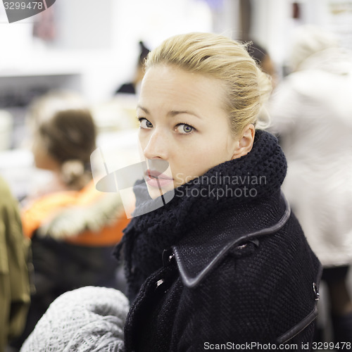 Image of Female shopper queuing in line at cashier.