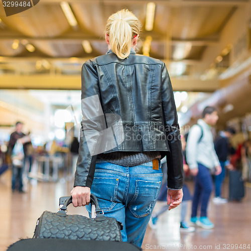 Image of Female traveller walking airport terminal.