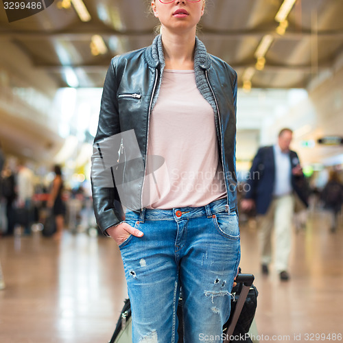 Image of Female traveller walking airport terminal.