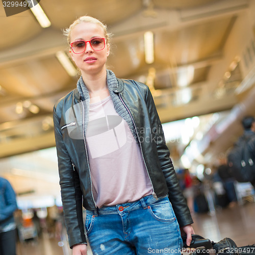 Image of Female traveller walking airport terminal.