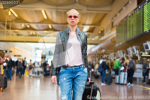 Image of Female traveller walking airport terminal.