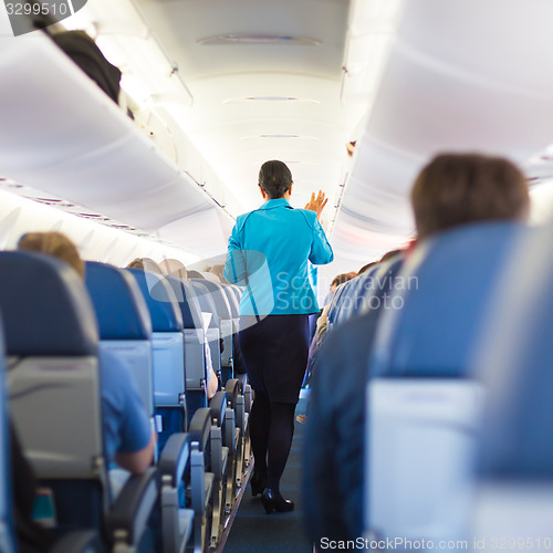 Image of Interior of airplane with passengers on seats.