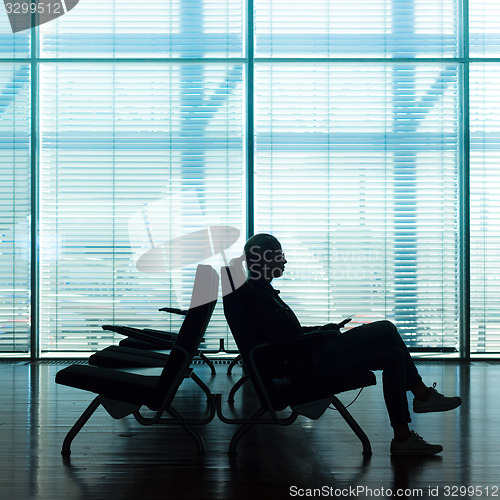 Image of Woman in transit waiting on airport gate.