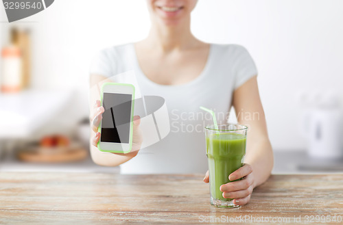 Image of close up of woman with smartphone and green juice