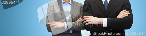 Image of businesswoman and businessman with crossed arms