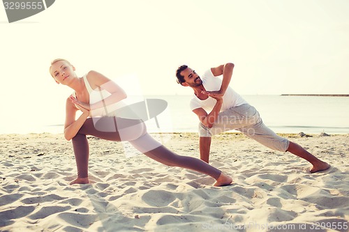 Image of couple making yoga exercises outdoors