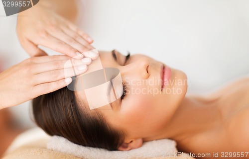 Image of beautiful woman in spa salon having facial