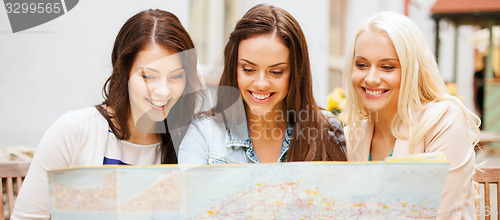 Image of beautiful girls looking into tourist map in city