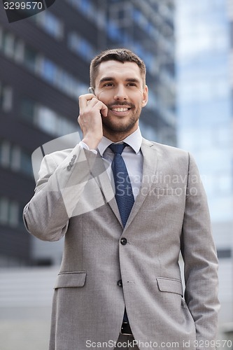 Image of smiling businessman with smartphone outdoors