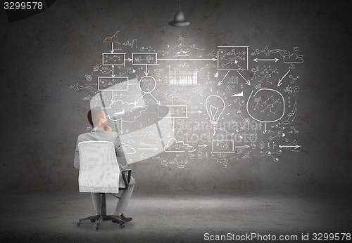 Image of businessman in office chair over white board
