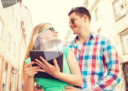 Image of smiling couple with tablet pc in city