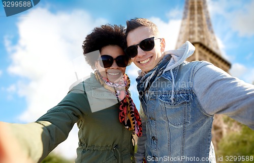 Image of happy couple taking selfie over eiffel tower