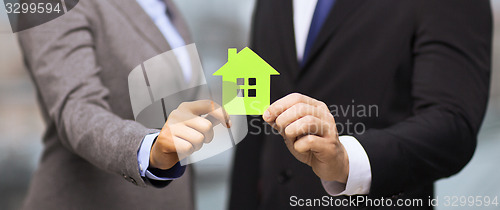 Image of businessman and businesswoman holding green house