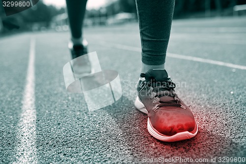 Image of close up of feet with red spot running on track