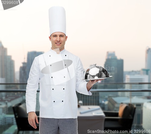 Image of happy male chef cook holding cloche