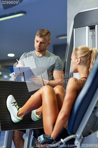 Image of man and woman flexing muscles on gym machine