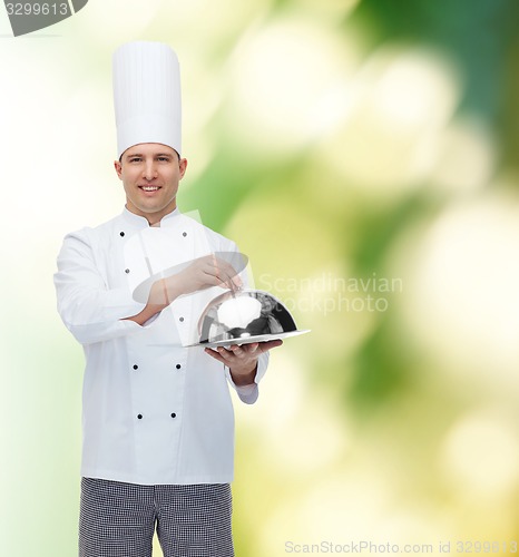 Image of happy male chef cook holding cloche