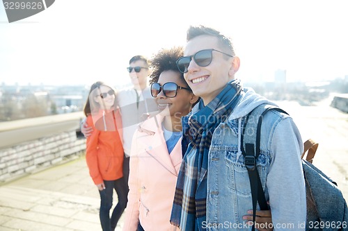 Image of happy teenage friends in shades hugging on street