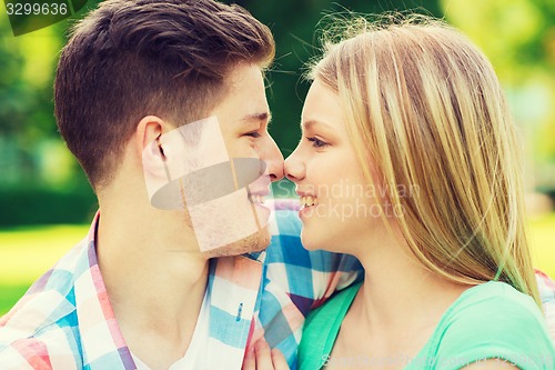 Image of smiling couple touching noses in park