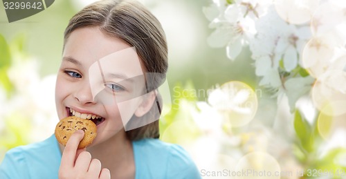 Image of smiling little girl eating cookie or biscuit