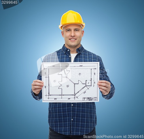 Image of smiling male builder in helmet with blueprint