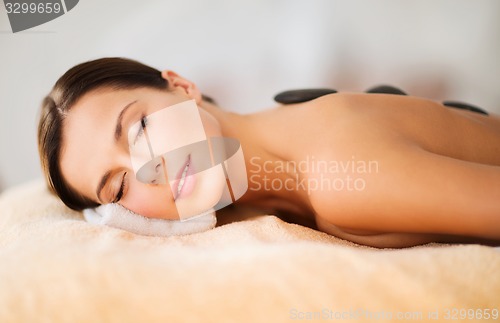 Image of beautiful woman in spa salon with hot stones