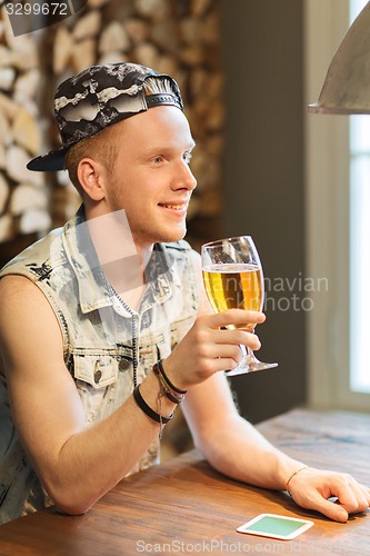 Image of happy man drinking beer at bar or pub