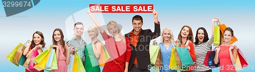 Image of happy people with red sale sign and shopping bags