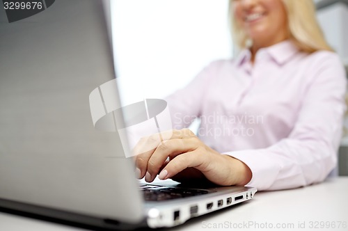 Image of smiling businesswoman or student typing on laptop