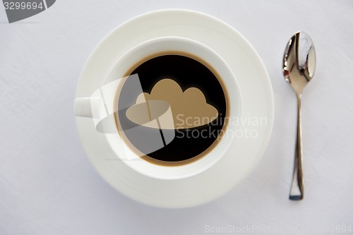 Image of cup of coffee with cloud silhouette and spoon