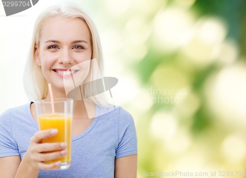 Image of smiling woman drinking orange juice