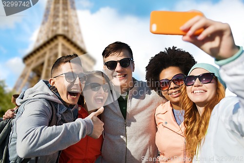 Image of smiling friends taking selfie with smartphone